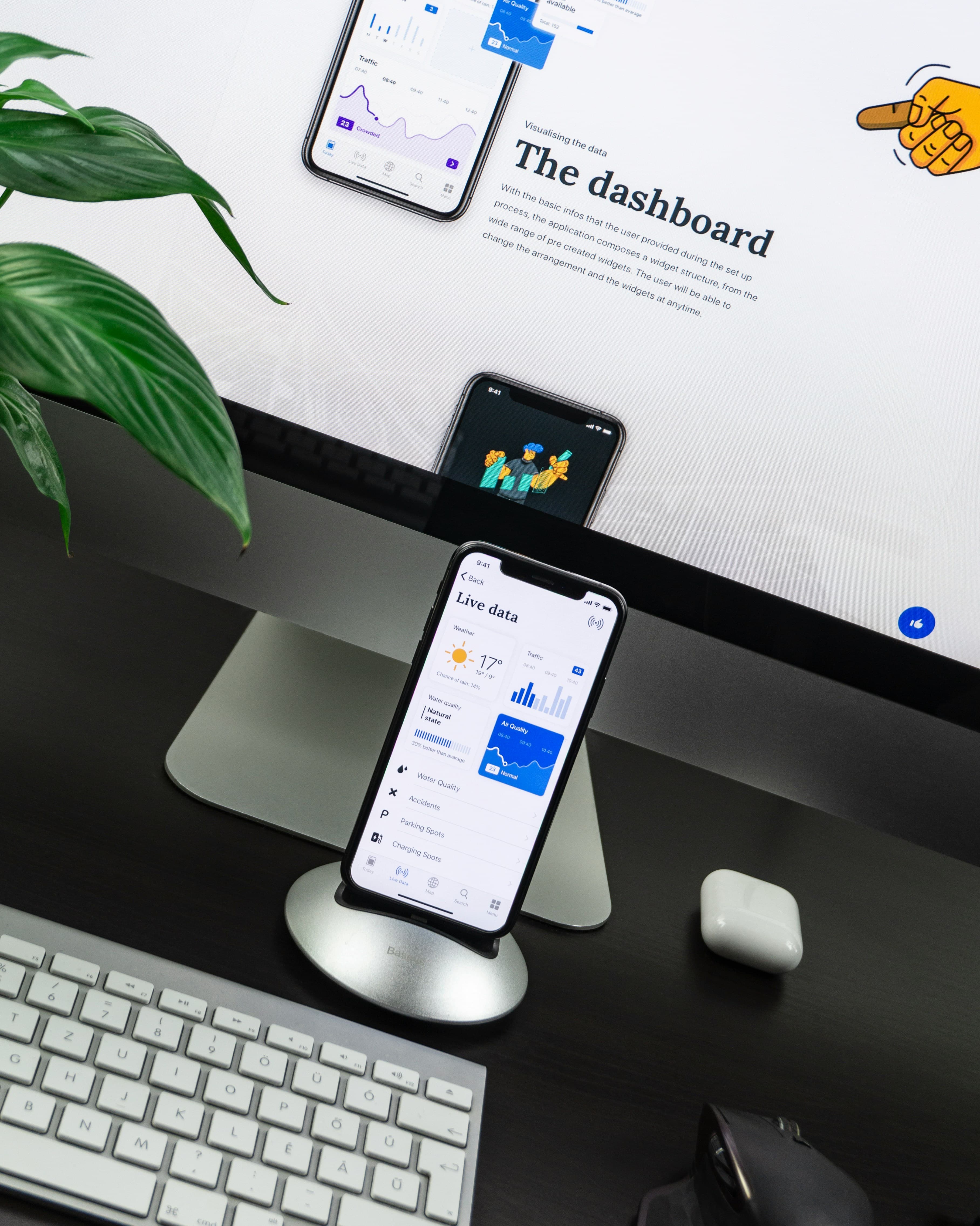 Smartphone on a stand displaying a live data app dashboard on a desk